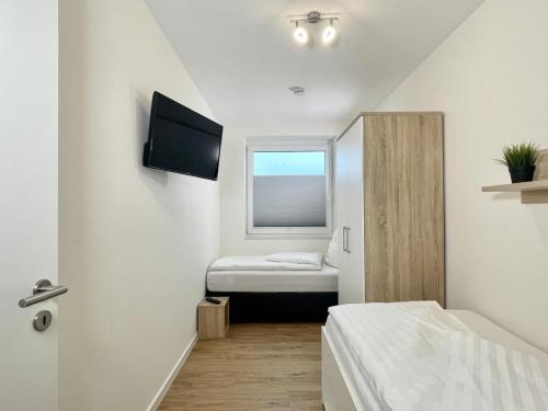 um pequeno quarto com uma cama e uma janela em Quartier Hohe Geest 2 em Sahlenburg