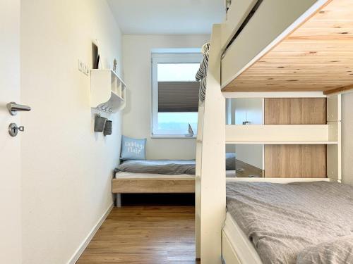 ein kleines Schlafzimmer mit einem Etagenbett und einem Fenster in der Unterkunft Quartier Hohe Geest 19 in Cuxhaven