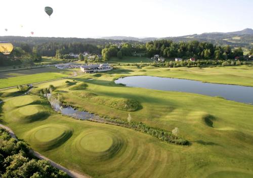 an aerial view of a golf course with a lake at Cityhotel am Domplatz Self-CheckIn in Klagenfurt