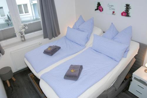 1 Schlafzimmer mit 2 Betten und blauen Kissen in der Unterkunft Meeresrauschen 6 in Großenbrode