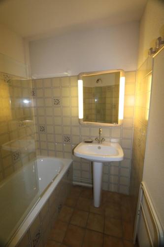une salle de bain avec un lavabo et une baignoire dans l'établissement Appartement vue piste Luc Alphand, à Saint-Chaffrey