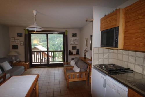 Il comprend une cuisine et un salon avec vue sur un balcon. dans l'établissement Appartement vue piste Luc Alphand, à Saint-Chaffrey