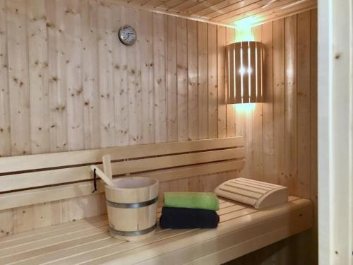 a sauna with a bucket and a clock on the wall at Haus Sonnendeck - Sonnenweg 21 in Heringhausen