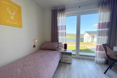 a bedroom with a bed and a large window at Sonnenweg 38 LAKEVIEW HOUSE Rubin Diemelsee in Heringhausen