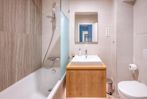 a bathroom with a sink and a toilet and a mirror at Napfény Resort by HelloBalatonlelle in Balatonlelle