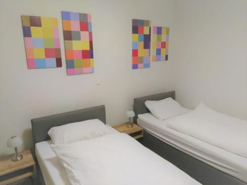 2 Betten in einem Zimmer mit Gemälden an der Wand in der Unterkunft Sonnenweg 17 in Diemelsee