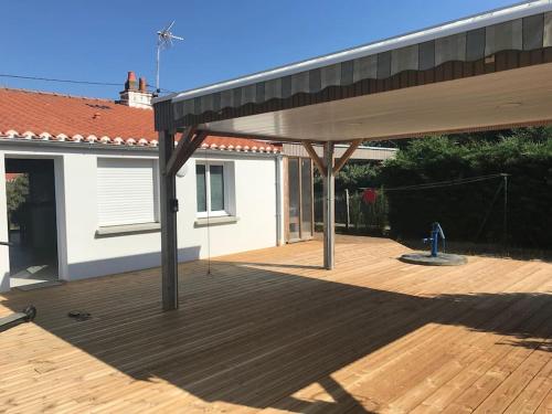une terrasse couverte avec un bâtiment et une borne d'incendie dans l'établissement Maison familiale au calme non loin de la mer, à Bretignolles-sur-Mer