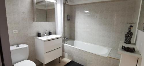 a bathroom with a toilet and a tub and a sink at La flemme en rose in Aigues-Mortes