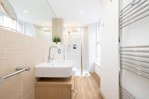 a bathroom with a white sink and a toilet at ALTIDO Splendid 2-BR Flat near Edinburgh Castle in Edinburgh