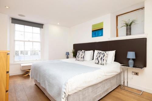 um quarto com uma cama grande e uma cabeceira preta em ALTIDO Splendid 2-BR Flat near Edinburgh Castle em Edimburgo