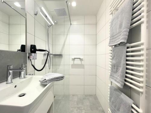 uma casa de banho branca com um lavatório e um chuveiro em Nino 17 em Nordhorn