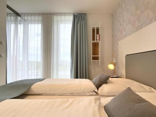 um quarto com 2 camas e uma grande janela em Nino 17 em Nordhorn