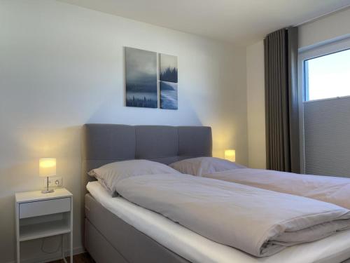 1 dormitorio con 1 cama grande y ventana en Diemelblick 12 - LENI, en Heringhausen