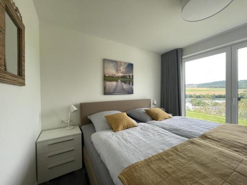 ein Schlafzimmer mit einem großen Bett und einem Fenster in der Unterkunft Ferienhaus SONNENWEG 8 in Heringhausen