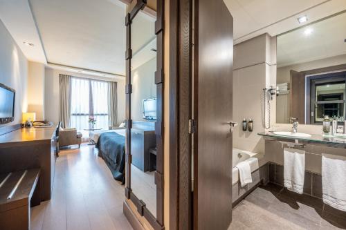 a hotel room with a bed and a bathroom at Hotel Nelva in Murcia