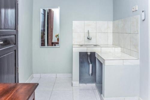 古邦的住宿－Amor Homestay near Eltari International Airport Mitra RedDoorz，白色的厨房配有水槽和镜子