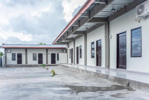 un aparcamiento vacío frente a un edificio en Amor Homestay near Eltari International Airport Mitra RedDoorz, en Kupang