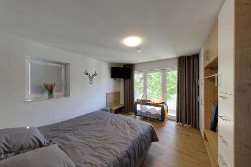 ein Schlafzimmer mit Bett, Schreibtisch und Fenster in der Unterkunft Haus Seeblick - Sonnenweg 14 in Diemelsee