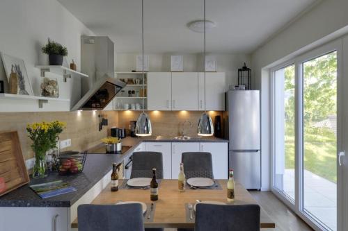 La cuisine est équipée d'une table, de chaises et d'un réfrigérateur. dans l'établissement Haus Seeblick - Sonnenweg 14, à Diemelsee