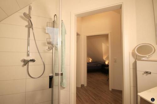 La salle de bains est pourvue d'une douche avec une porte en verre. dans l'établissement Ferienhaus am Angerplatz, à Cuxhaven