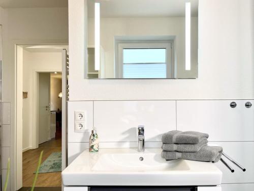 bagno con lavandino bianco e specchio di Kirschgarten 3 a Kellenhusen