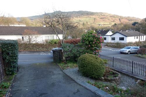 a street with a car parked next to a fence at Wansrigg in Ambleside
