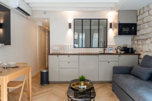 une cuisine et un salon avec un canapé et une table dans l'établissement Lavie Maison A C & Sauna, à Paris
