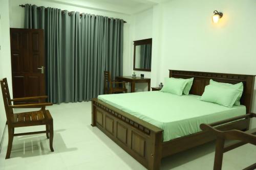 una camera con un grande letto e una sedia di Qualia Resort a Matara