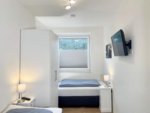 ein kleines Schlafzimmer mit einem Bett und einem Fenster in der Unterkunft Quartier Hohe Geest 22 in Cuxhaven