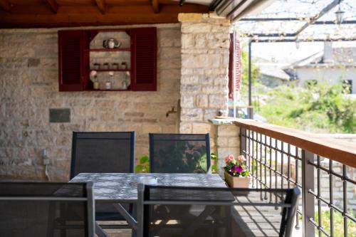 a patio with a table and chairs on a balcony at Βερβερίτσα in Monodendri