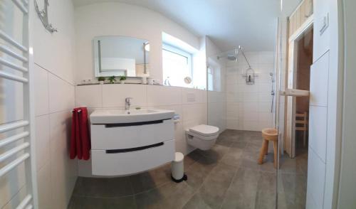 a white bathroom with a sink and a toilet at Neue Liebe Haffkrug 1 in Haffkrug