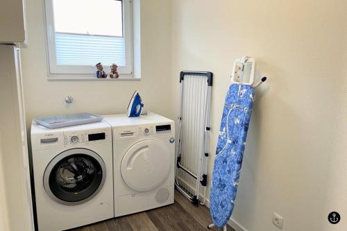 eine Waschküche mit einer Waschmaschine und einem Fenster in der Unterkunft Neue Liebe Haffkrug 4 in Haffkrug
