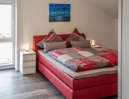 a red bed in a room with a red couch at Neue Liebe Haffkrug 5 - Meeresstern in Haffkrug