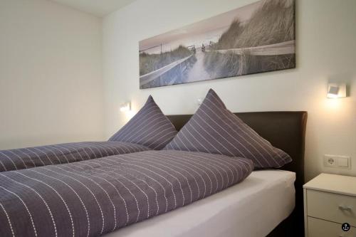 um quarto com uma cama com almofadas roxas em Refugium 6 em Kellenhusen