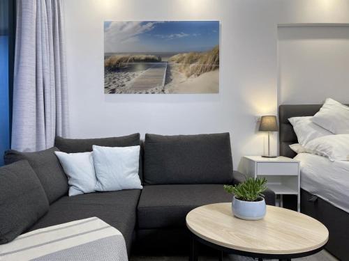 een woonkamer met een bank en een bed bij Maritim Residenz 6 - Sea Lounge in Travemünde