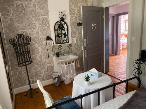 a room with a table and a sink in it at Les Iris Chambres d’hôte in Niedermorschwihr