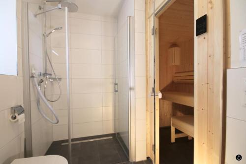 łazienka z prysznicem, toaletą i schodami w obiekcie Refugium 3 w mieście Kellenhusen