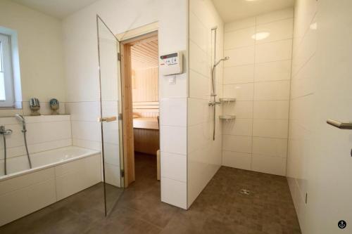 uma casa de banho com um chuveiro, uma banheira e um lavatório. em NINA - Sonnenweg 20 em Heringhausen
