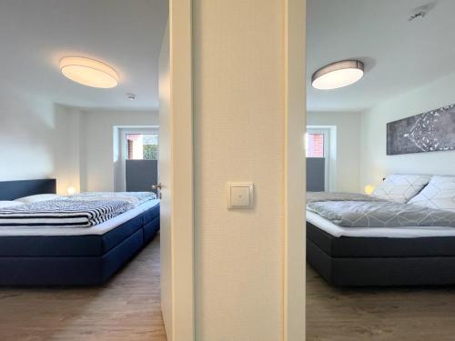 Zimmer mit 2 Betten und einer Tür zu einem Schlafzimmer in der Unterkunft Hansehaus 16 in Grömitz