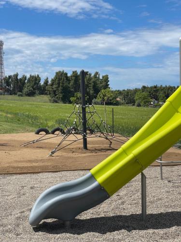 a yellow and gray slide in a playground at Sani Verde in Sani Beach