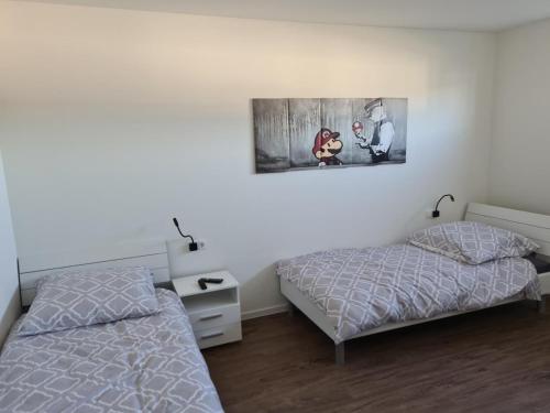 1 dormitorio con 2 camas y un cuadro en la pared en Sonnenweg 34, en Diemelsee