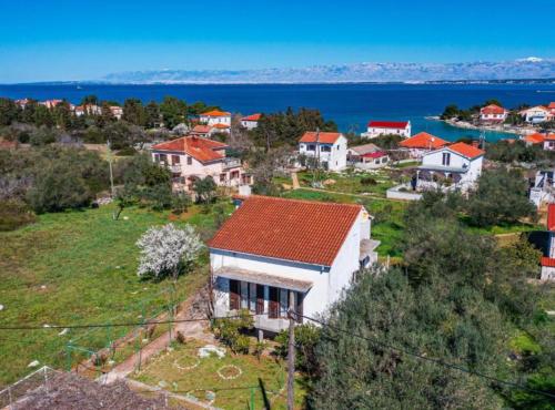 a house on a hill with the ocean in the background at Apartment Serđa in Ugljan