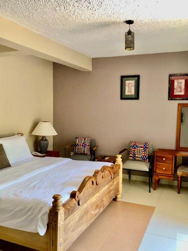 a bedroom with a large bed and two chairs at The Address Resort in Kalangala