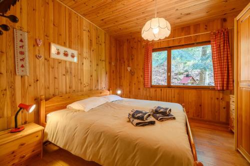a bedroom with a bed in a wooden cabin at Chalet Les Airelles in Mittlach
