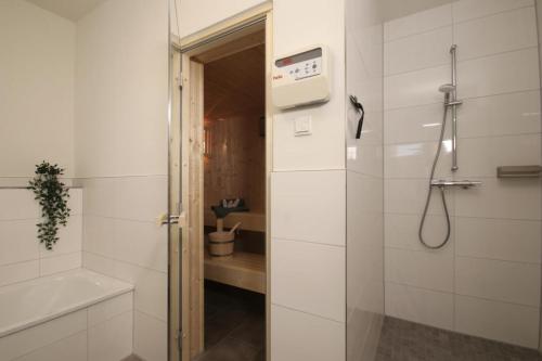 a white bathroom with a shower and a toilet at Sonnenweg 30 in Heringhausen