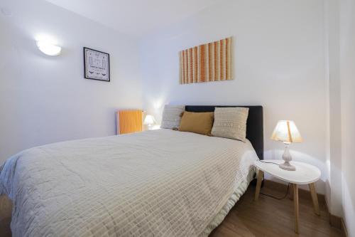 - une chambre avec un lit, une table et une lampe dans l'établissement L'Albera - Charmant appartement vue mer, à Canet