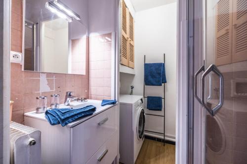 une salle de bain avec un lavabo et une machine à laver dans l'établissement L'Albera - Charmant appartement vue mer, à Canet