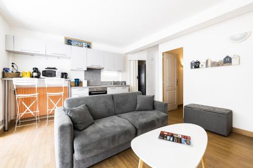 un salon avec un canapé et une cuisine dans l'établissement L'Albera - Charmant appartement vue mer, à Canet