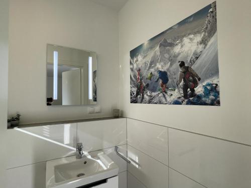 un baño con lavabo y una pintura en la pared en Sonnenweg 11, en Heringhausen