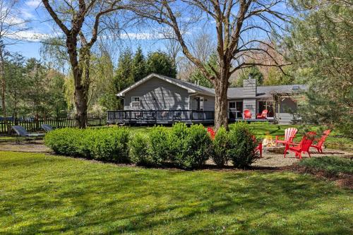 a house with a deck and chairs in a yard at Hidden Haven in Union Pier
